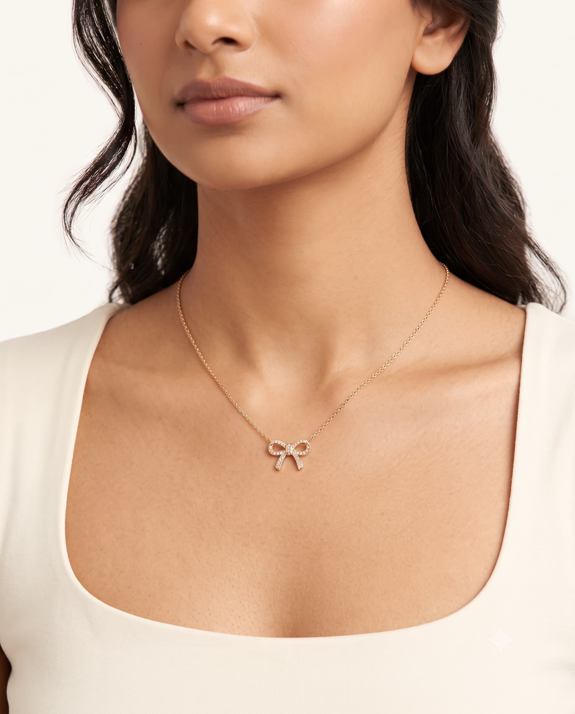 Model wearing a bow pendant necklace