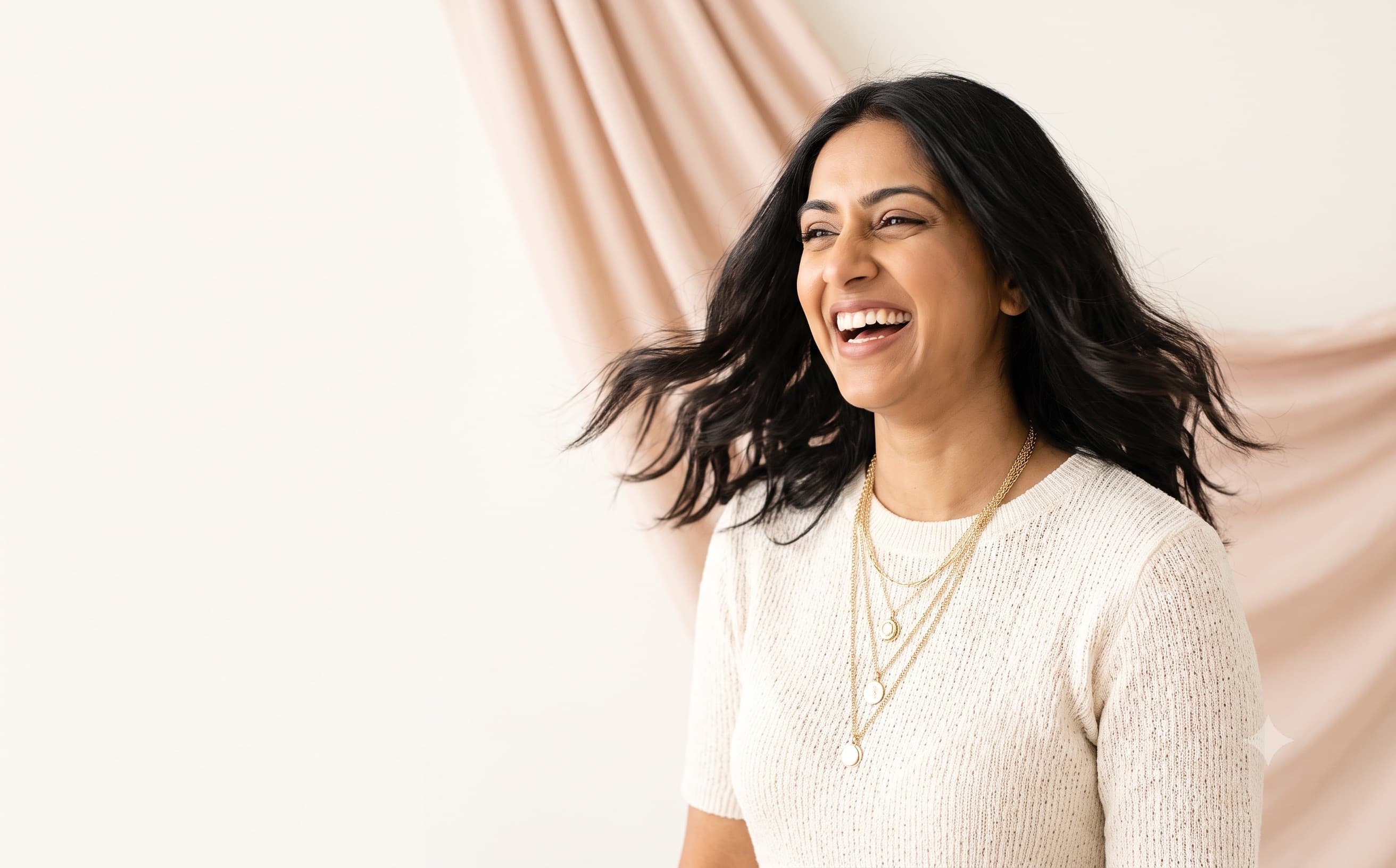Model laughing while wearing a layered necklace